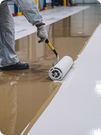 Technician applying epoxy coating to a garage floor