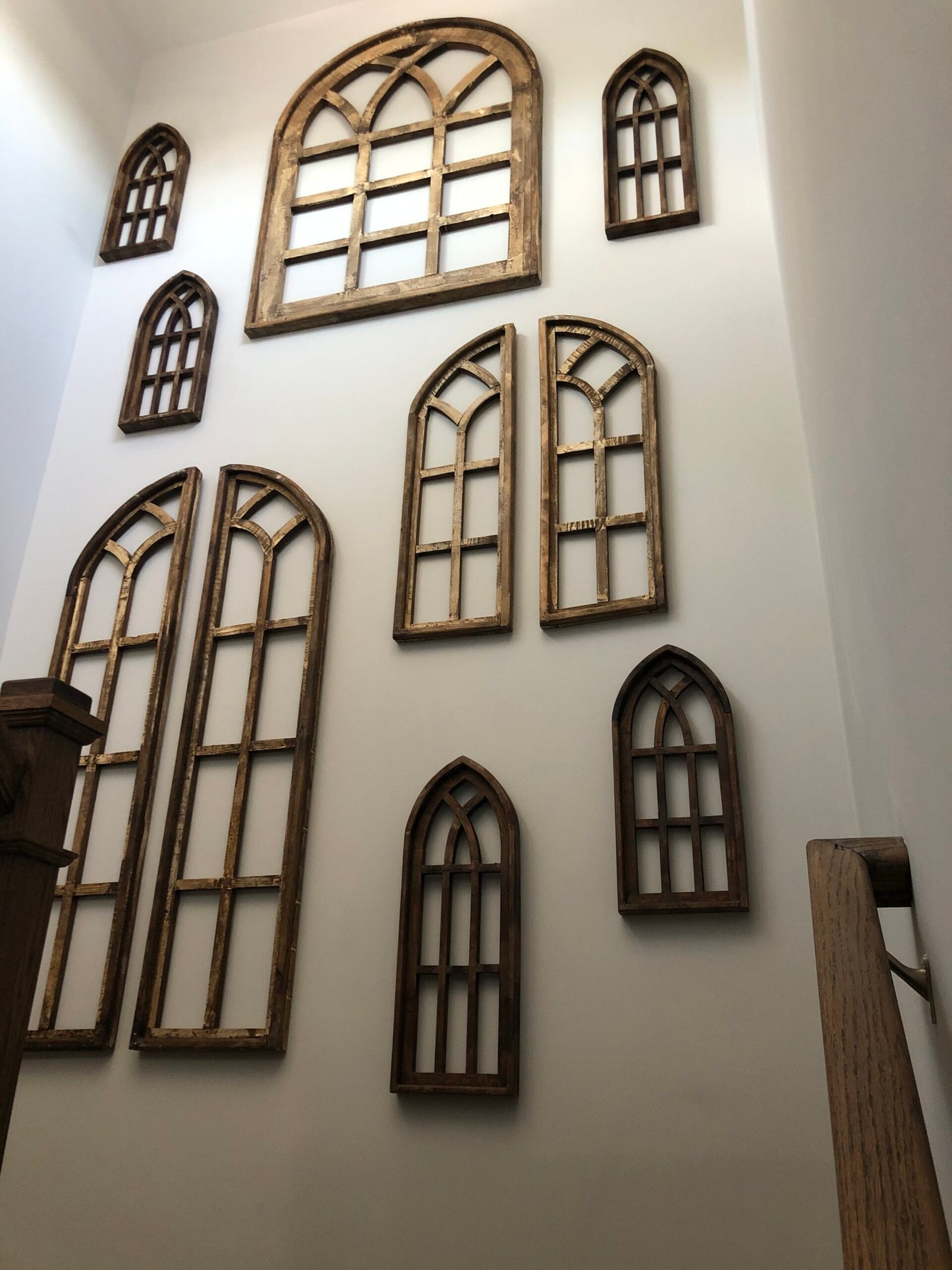 Decorative wall featuring multiple framed mirrors and art installations